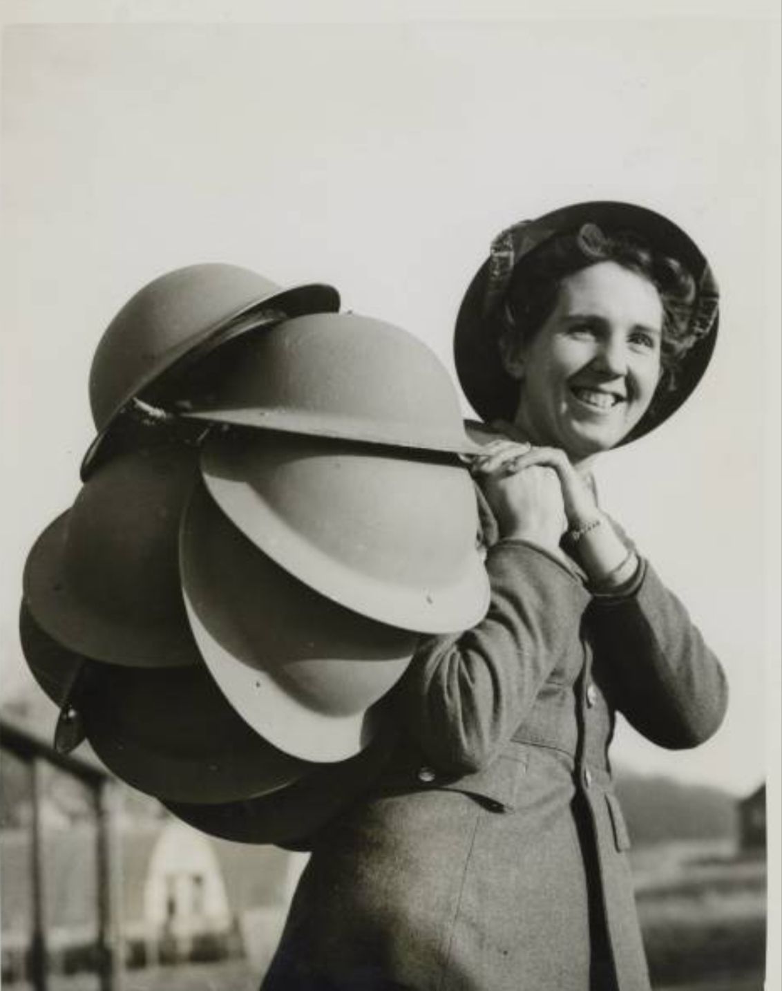 A cheery smile from 21yo ATS Lance Corp. Goldsmith as she takes a load of steel helmets to the...jpg