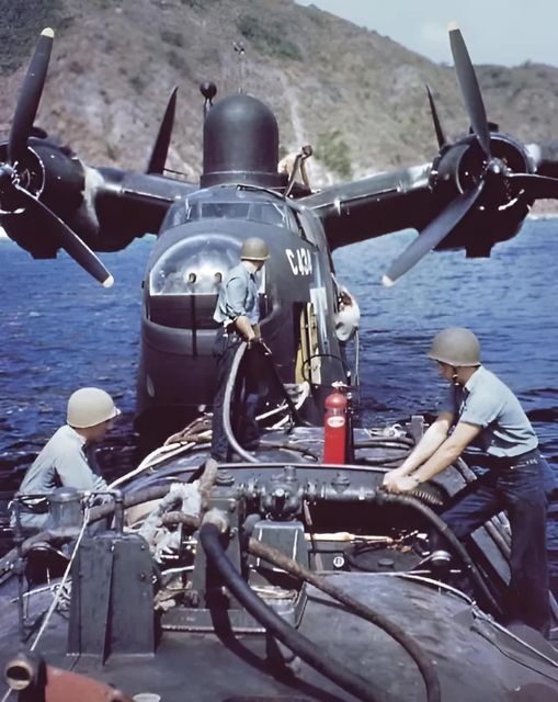 A Martin PBM-5 Mariner, Fleet Air Wing One refuels from a fuel bowser boat in Tanapag Harbor, ...jpg