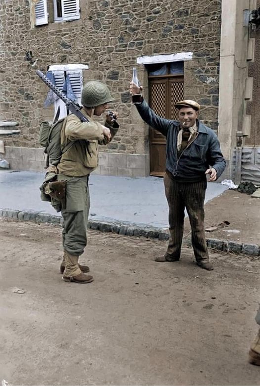 , aFrench offers a glass of wine to an American soldier.jpg