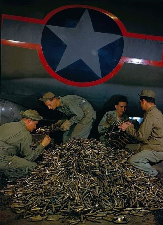 Ground crew of the US 8th Army Air Force collecting empty .50 caliber shells from a B-17 Flyin...jpg