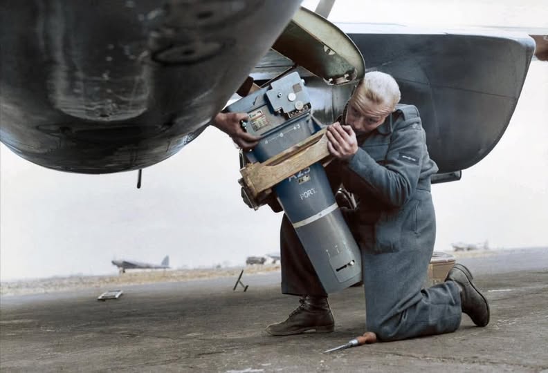 Ground team fitting a Type F.52 camera with 36-inch lens through the starboard side loading-ha...jpg