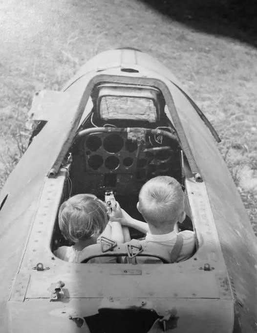 Kids playing in a cockpit of a German Me-262 Schwalbe fighter abandoned at the end of World Wa...jpg