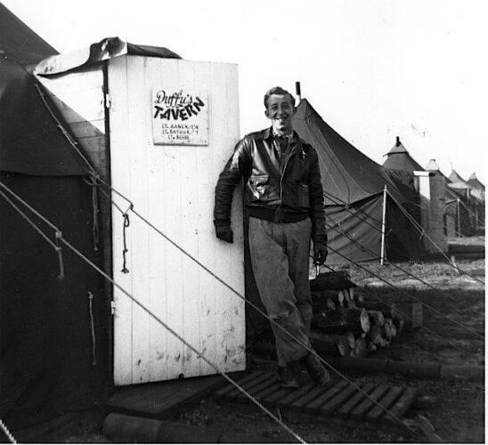 P-47 Pilot Quentin C. Aanenson of the 391st Fighter Squadron leans on the door of his tent, wh...jpg