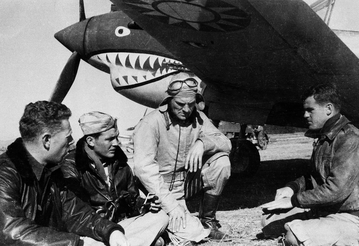 Pilots from the American Volunteer Group sit in front of a P-40 airplane in Kunming, China,.jpg