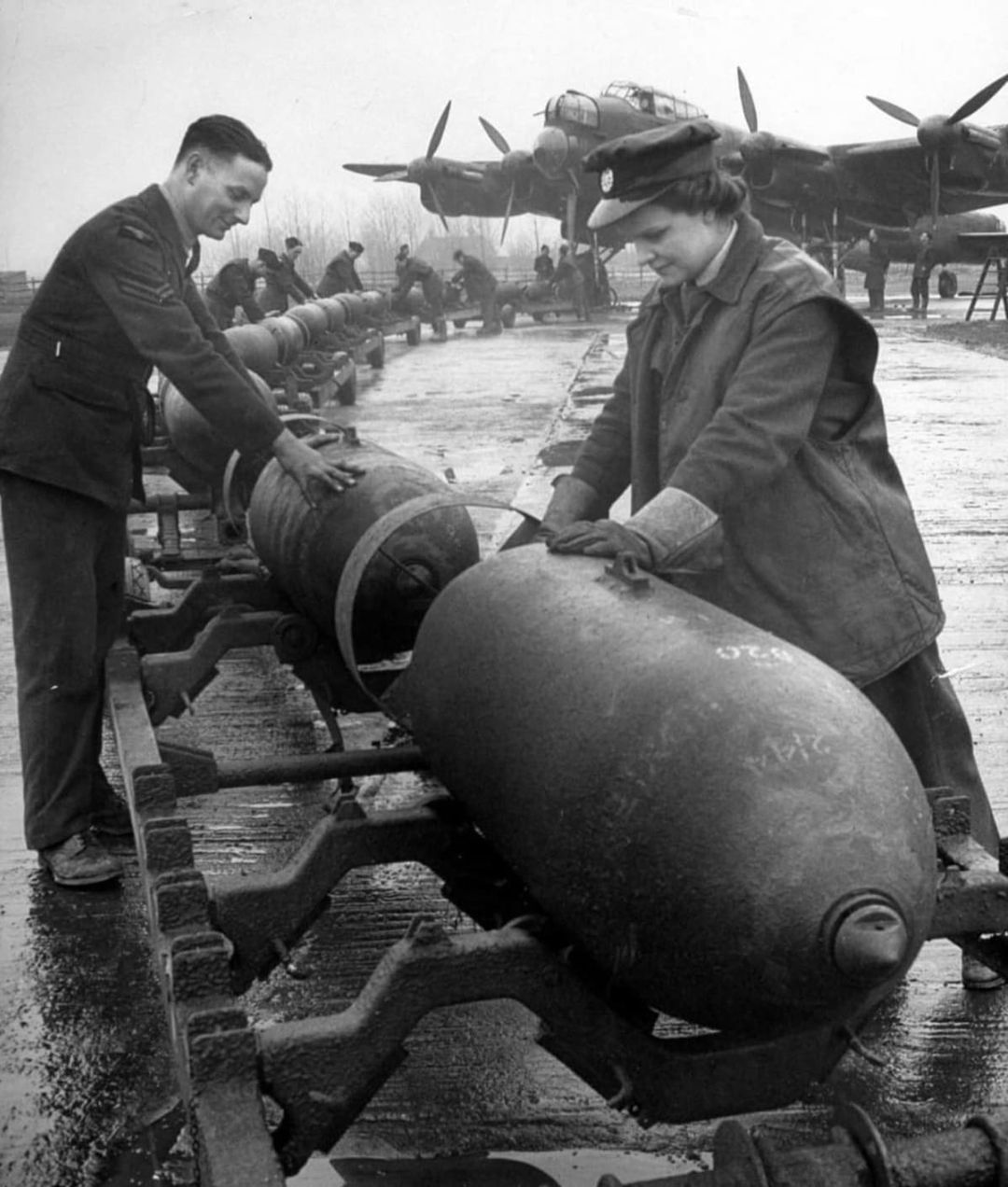 RAF Ground personnel, including WAAF transport driver Peggy Meek, with 1,000lb bombs being rea...jpg