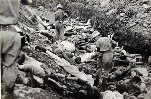 South_Korean_soldiers_walk_among_dead_political_prisoners,_Taejon,_South_Korea.jpg