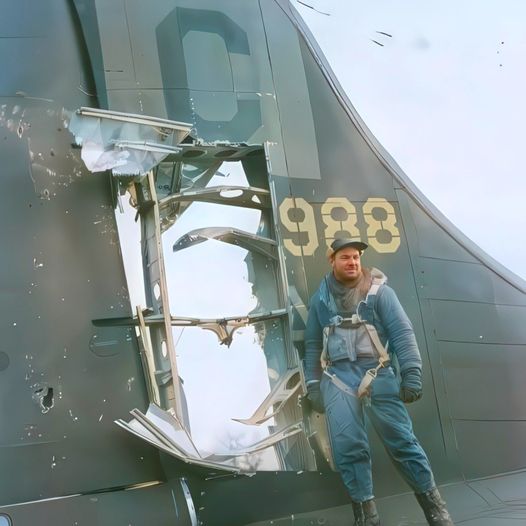 tail gunner SSgt Charles Haywood 96th Bomb Group stands with a giant flak hole on the tail of ...jpg