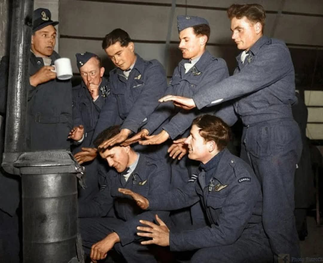 The crew of Avro Lancaster %22C for Charlie%22 of No. 44 (Rhodesia) Squadron RAF, try to warm ...jpg