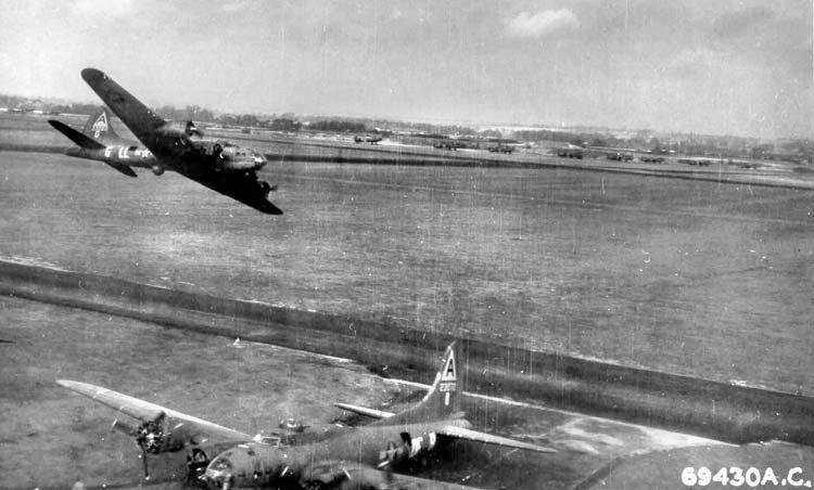 The crew of B-17F Hell Belle celebrate their 25th mission by buzzing the airfield at Bassingbo...jpg