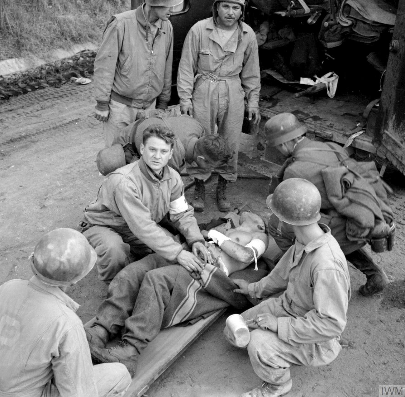 US & German Personnel treat a wounded Soldier during the Battle of Anzio, Italy - February 6, ...jpg