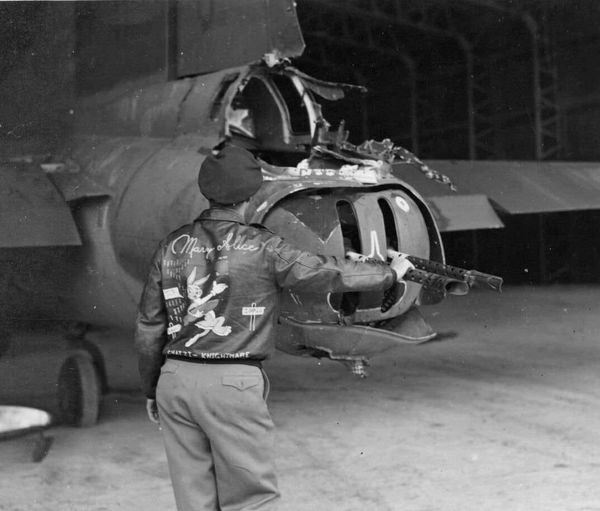 USAAF Lt Dan Knight, a pilot of the 401st Bomb Group, inspects damage to the tail gun position...jpg